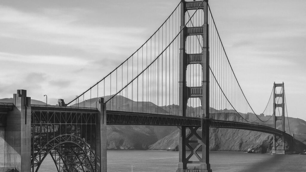 Why the Golden Gate Bridge Is One of the Greatest Engineering Marvels in History 5 Black and white photo of the Golden Gate Bridge under construction, showing steel towers, scaffolding, and the early engineering structure spanning the Golden Gate Strait.