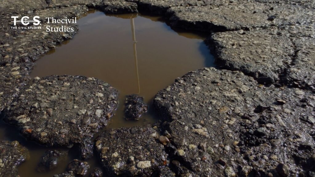 Why Do Roads Deteriorate? The Complete Science Behind Pavement Failure and Cracking 2 Worn asphalt road showing surface cracks and a shallow pothole, indicating early-stage pavement failure